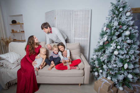European family sitting on the sofa near Christmas tree with giftsの写真素材