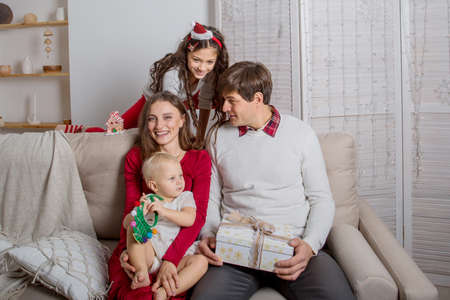 European family sitting on the sofa with Christmas gifts