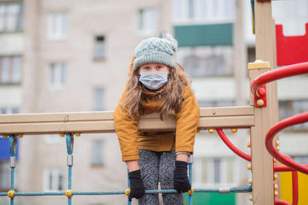 Little girl in medical mask. At atumn playgroundの写真素材