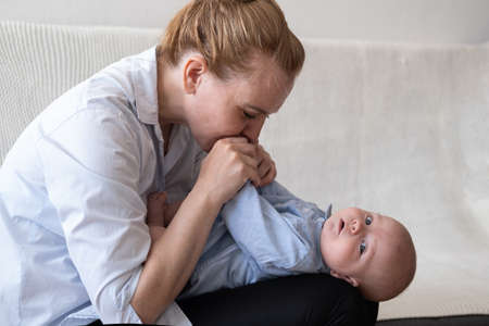 Attractive happy mother play kiss little baby boy. Happy familyの写真素材
