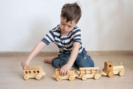 Little boy playing with wooden train. eco toys