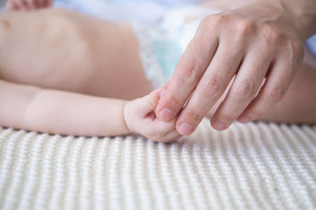 mothers hand holding little baby boys hand. Happy family