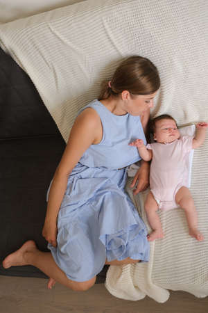 Attractive happy mother lying with little baby girl. Happy familyの写真素材