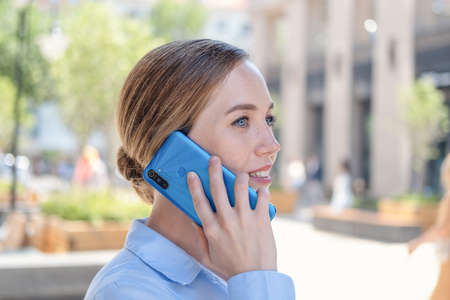 happy confident business woman talking on phone stand in cityの写真素材