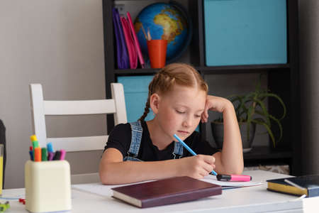 cute caucasian redhead girl studying at homeの写真素材