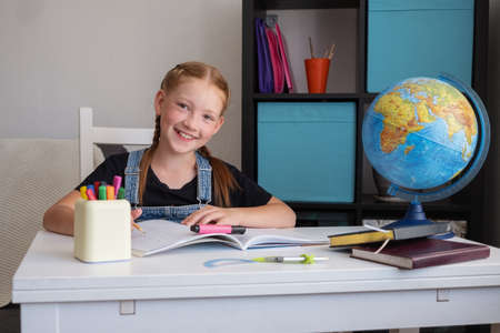 cute happy caucasian redhead girl studying at homeの写真素材