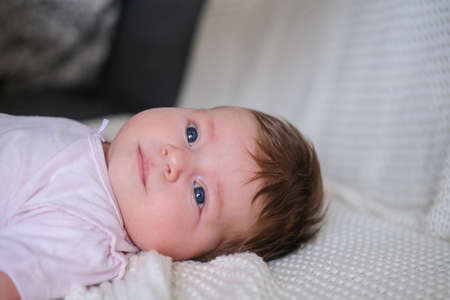 cute little baby girl lying on white plaid. Happy familyの写真素材