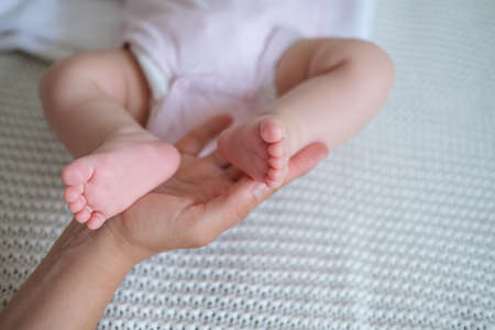 mothers hands hold little babys toes. Happy familyの写真素材