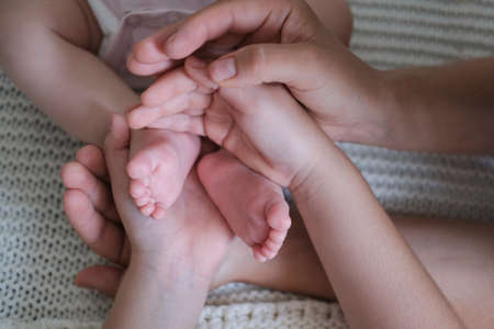 mothers hands and kid hands hold little babys toes. Happy familyの写真素材