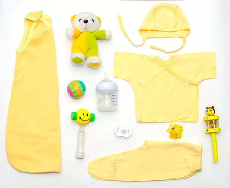 top view of baby girl yellow clothes and toy stuff, baby fashion conceptの写真素材
