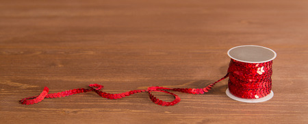reel of sequil ribon on brown wooden table backgroundの写真素材