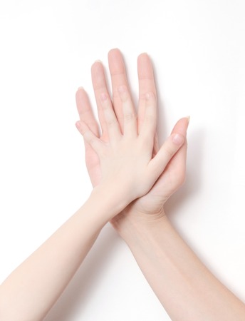 childs's hand and adult's hand on white backgroundの写真素材