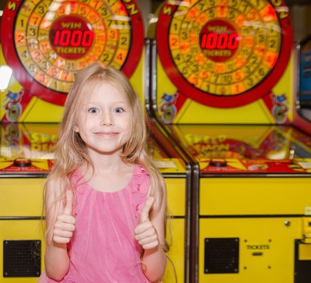 little girl standing and playing at indoor amusement parkの写真素材