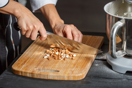 almonds cutting steel knife on the kitchen blackboardの写真素材