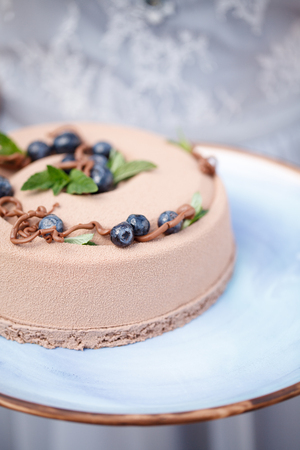 delicious creamy brown cake closeup on blue plateの写真素材
