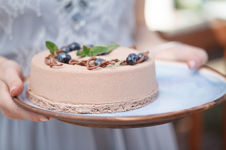 Baker hands holding delicious creamy cake closeupの写真素材