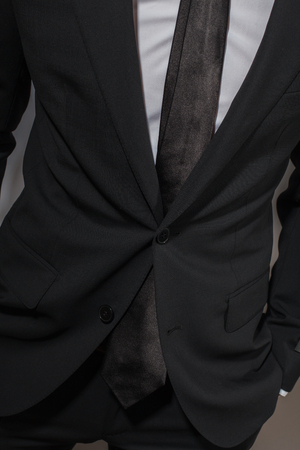 A man in a black suit and a white shirt with a black tieの写真素材