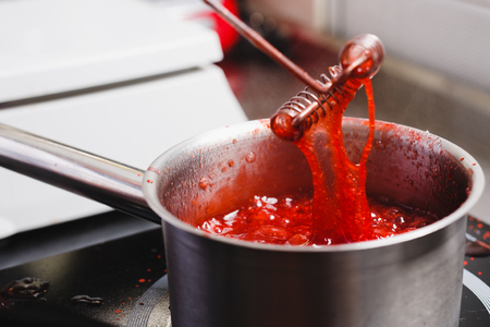 Boiling strawberry puree in a saucepan, close upの写真素材