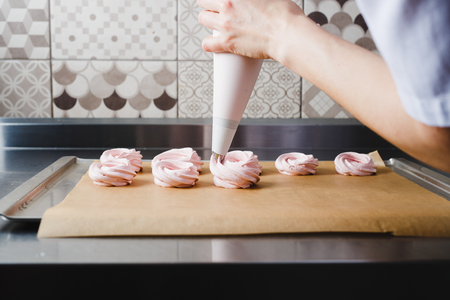Extrusion of the zephin mass from the culinary bag onto the baking trayの写真素材