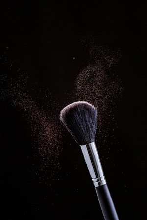 Brush and cloud powder on a black backgroundの写真素材