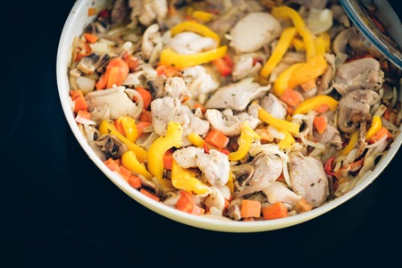 Chicken stew with mushrooms and vegetables in a yellow frying panの写真素材