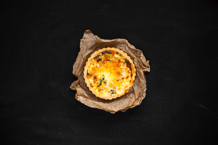 kish with onions and cheese. cheese cake. on a black background.
