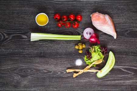 Ingredients for cooking, chicken breast and vegetables on a wooden tableの写真素材