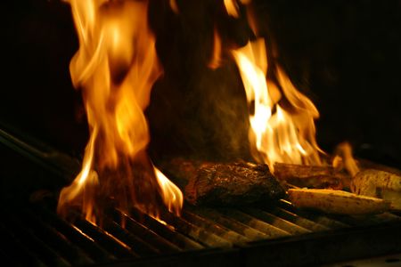 Steak cooking on wood fired flame grill in Restaurantの写真素材