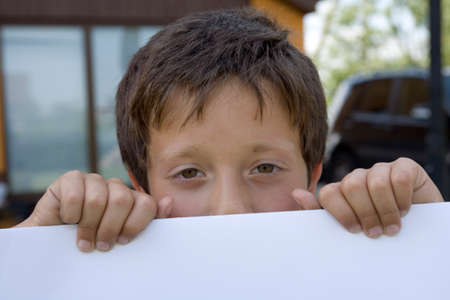 Boy keeps sheet of paperの写真素材