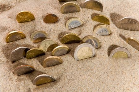 Coin and financial crisis on sandの写真素材