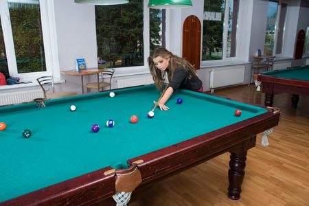 Young girl in short skirt playing snooker