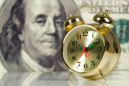 Clock on big dollar backgroundの写真素材