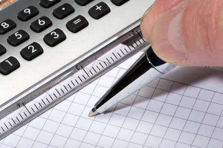 calculator and pen on a white backgroundの写真素材