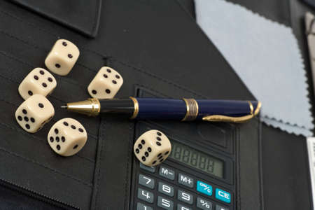 Calculator, pens, dice and financial concept