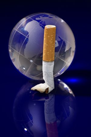 Glass globe with cigarette on blue backgroundの写真素材