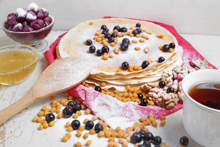 Carnival celebration, delicious pancakes close-up, with a fresh blueberry and sea buckthorn,...
