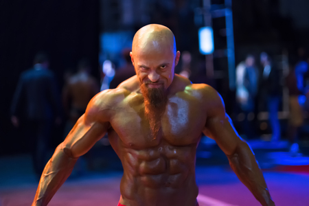Bodybuilding contest behind the scenes: the contestant is preparing for the performance. Selective focus.の写真素材