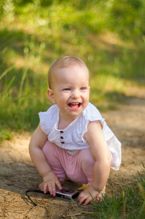 happy child girl hiding in ferns while playing in summer forest. Outdoor.の写真素材