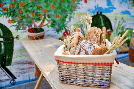 Bread basket outdoors on a wooden table in a street cafe, closeuの写真素材