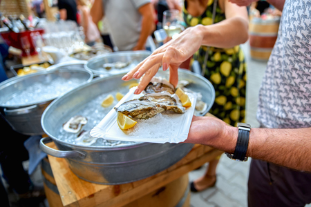 close-up of an oyster with a lemon, like snacks. woman is pickinの写真素材