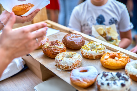 Close-up of tasty baked donuts with glazing and berries in sunliの写真素材