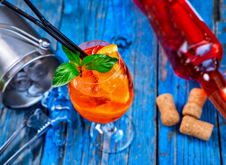 Spritz Aperol cocktail in a glass and ice cubes on a rustic wooden background, copy space.の写真素材