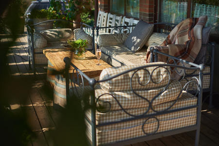 Cozy terrace with sofas for rest, Glass with champagne on a wooden table. Sunny day.の写真素材