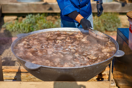 The process of making soup from lamb - shurpa in a cauldron in the open air.の写真素材