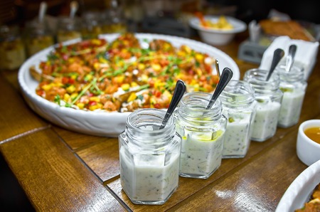 Buffet table with Bruschetta, Appetizers and different sauces. with hummus, beef, pate, avocado, tomatoes. on a wooden rustic table. Close-up. selective focus.の写真素材