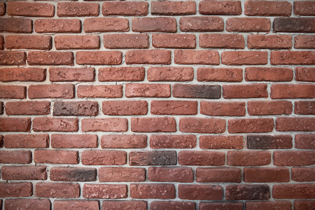 Abstract weathered texture of stained old dark stucco brown and painted red, yellow brick wall background in rural room Grungy rusty blocks of stonework tech darken retro color architecture wallpaperの写真素材