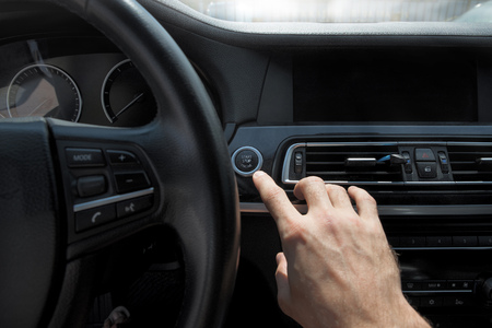 Pictures of the beginning of the journey by car,Focus on finger. hand presses the start button of...
