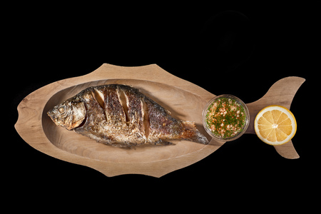 Grilled Fish Dorado with Lemon On a black background. Copy space.