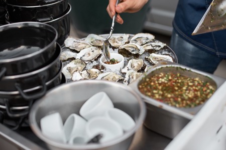 Close Up of Server with Tray of Fresh Shucked Oysters with Lemon Wedges Served as Appetizerの写真素材
