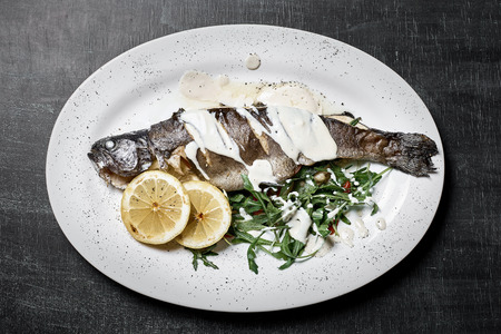 Roasted seabass with rosemary and herbs, selective focus, copy space.の写真素材